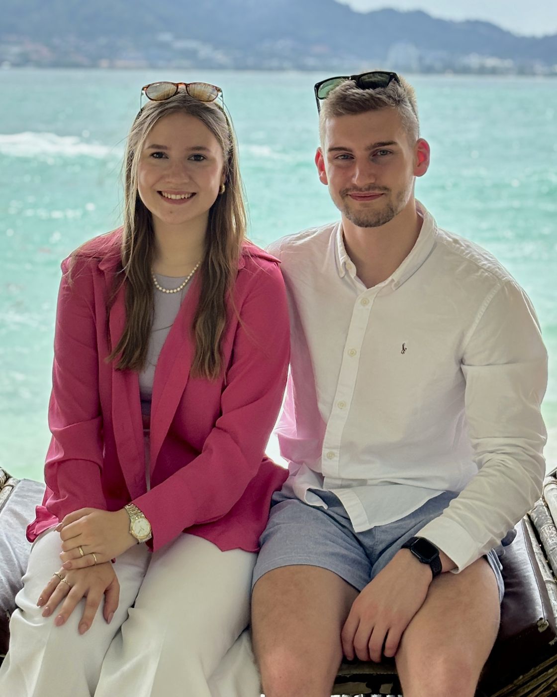 Theresa und Jan sitzen lachend am Meer